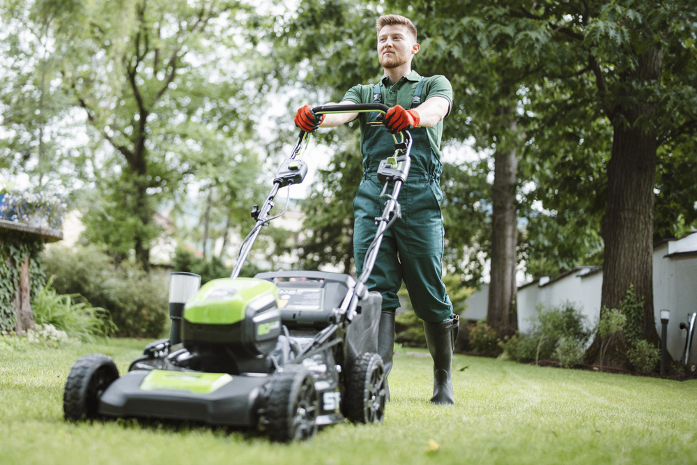 Small business owner mowing customer lawn